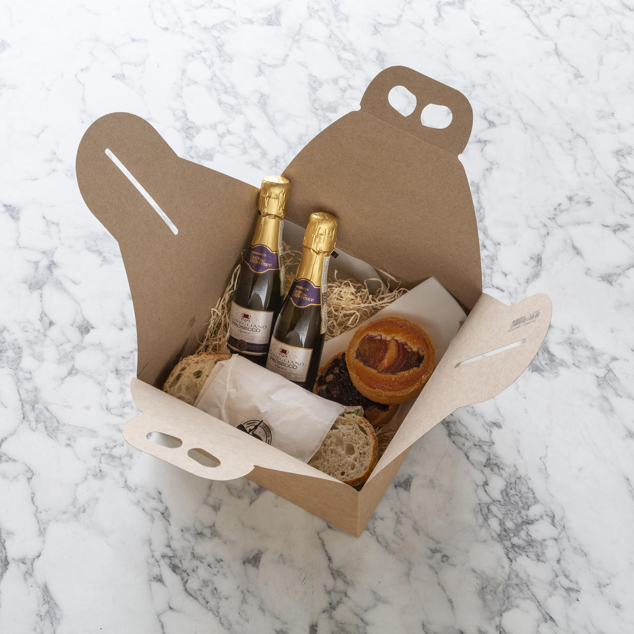 Kraft cake or panettone gift box with carrier handle from high-density rigid paperboard.