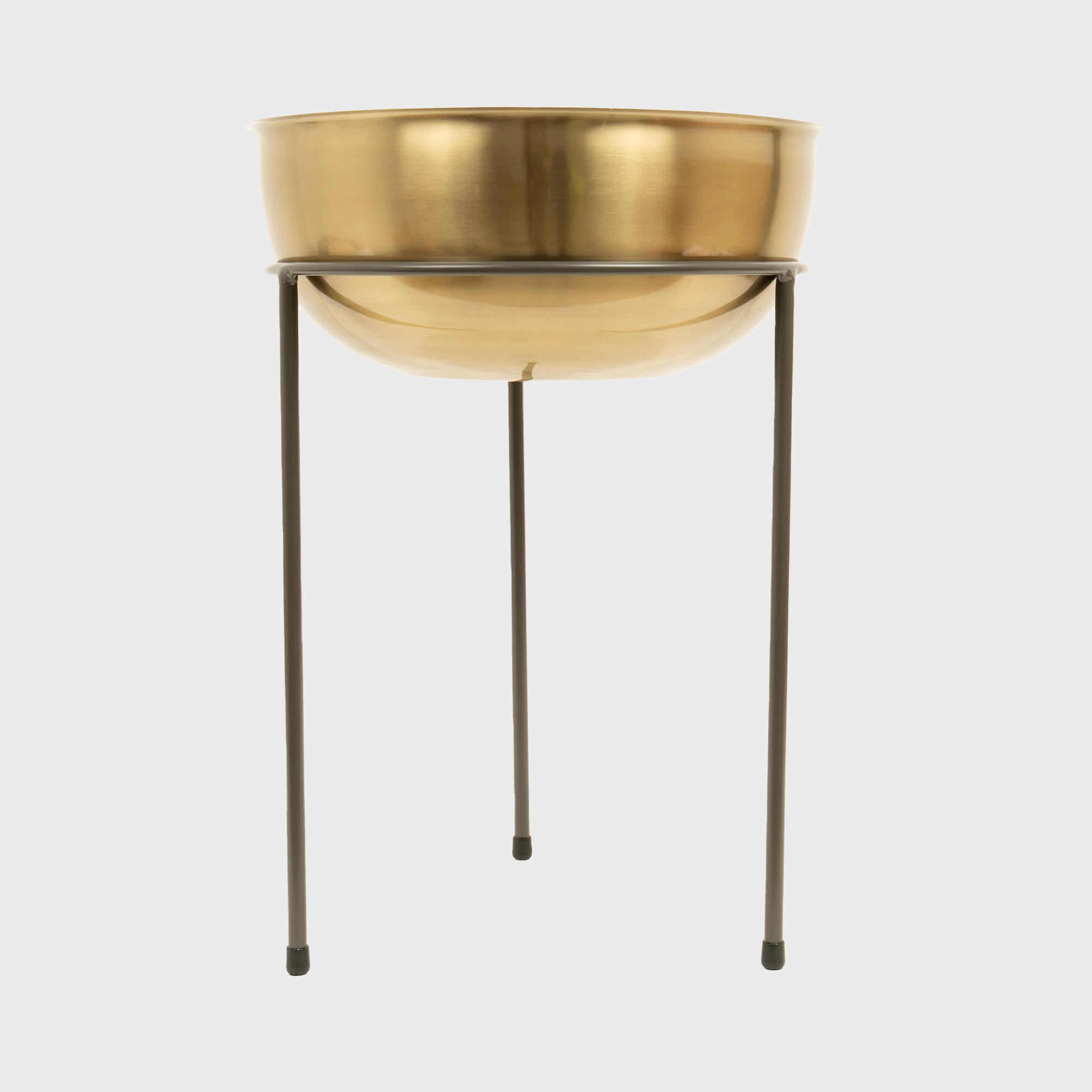A matte brass bowl on a metal riser.