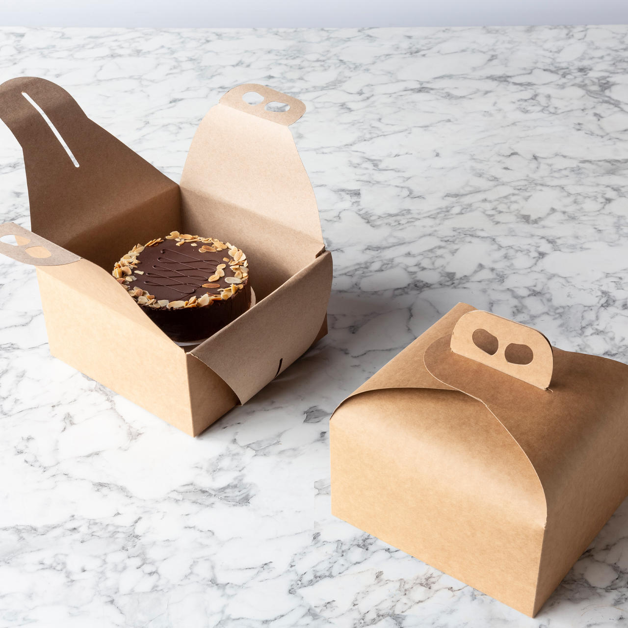 Kraft cake or panettone gift box with carrier handle from high-density rigid paperboard.