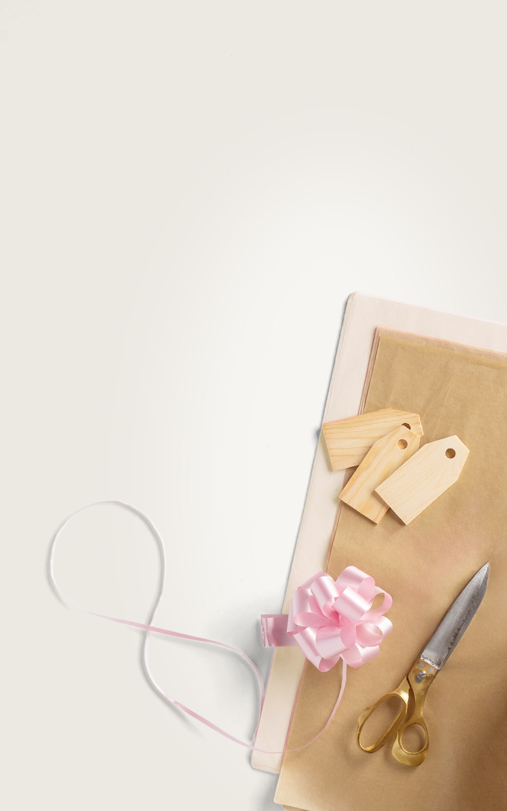 Gift wrapping paper with a pink bow and scissors on a white background