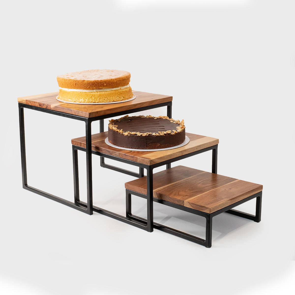 Natural acacia wood and steel riser set of 3 designed to add functional height and dimension.