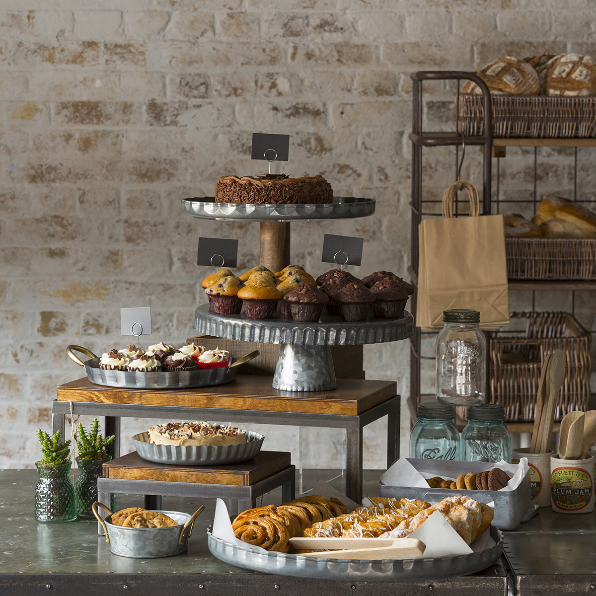 Galvanised metal cake stand with scalloped edge featuring a stable base and decorative scalloped edge.