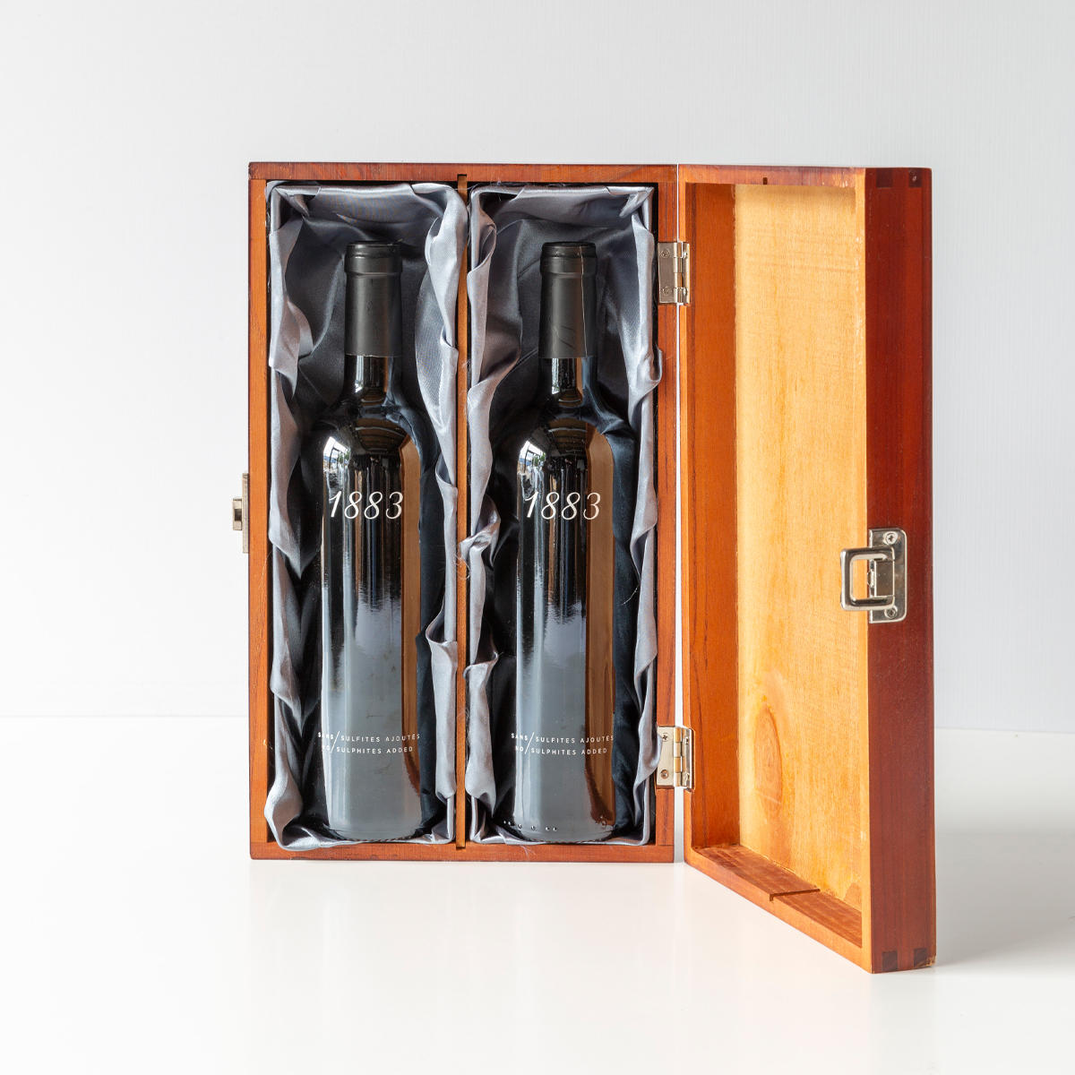 Silk lining for wooden bottle boxes with premium natural wood grain and secure hardware closures.