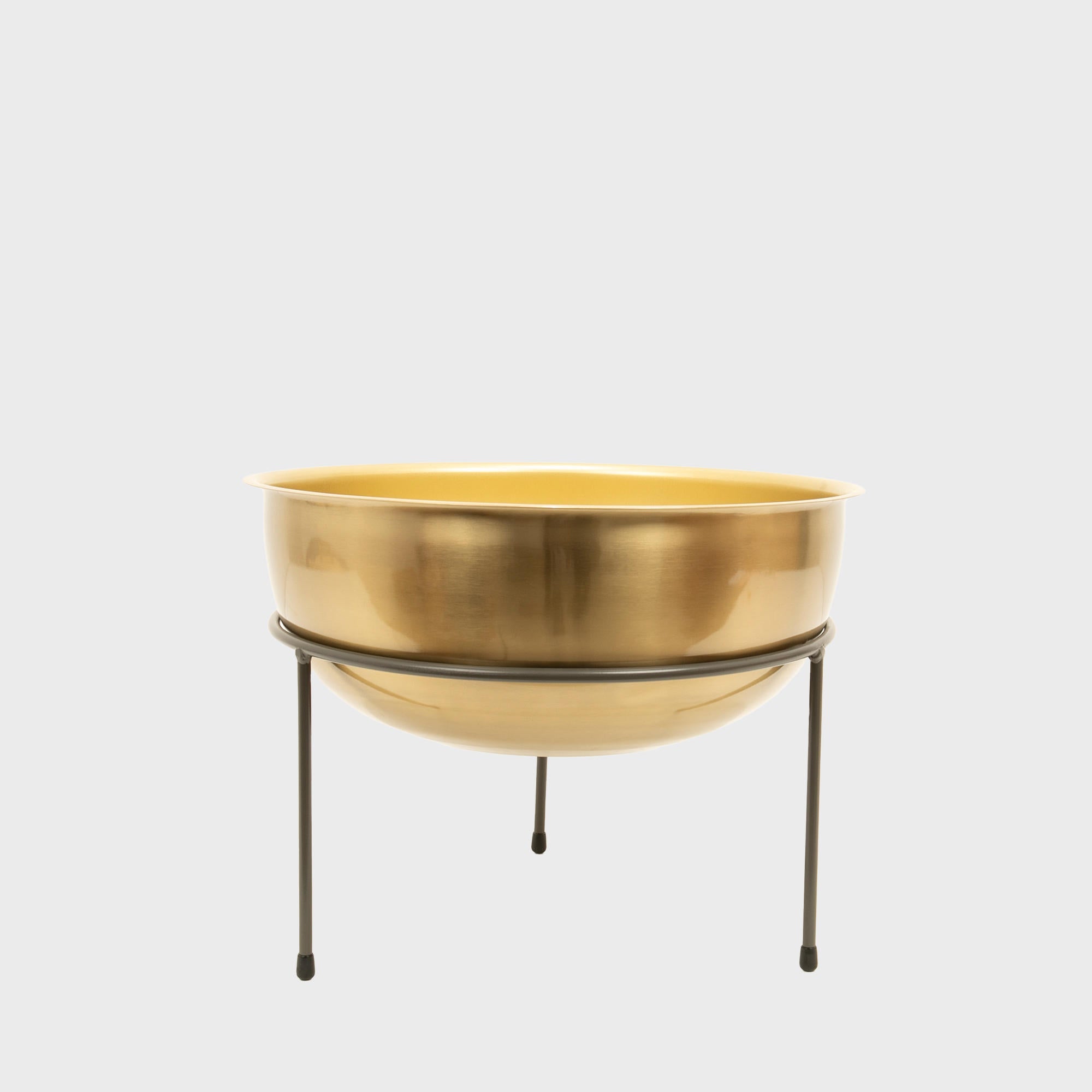 Matlock metal riser with matte brass bowl designed to add functional height and dimension.
